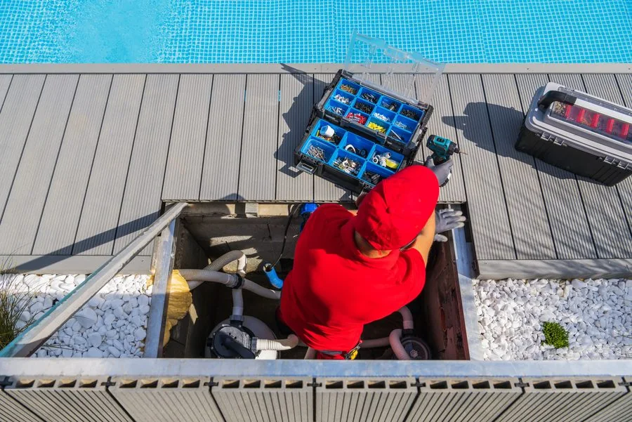 Technician servicing pool equipment and filtration